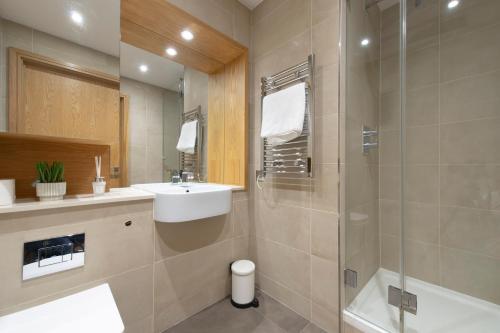 y baño con lavabo y ducha. en Canary Luxe Apartment, en Londres