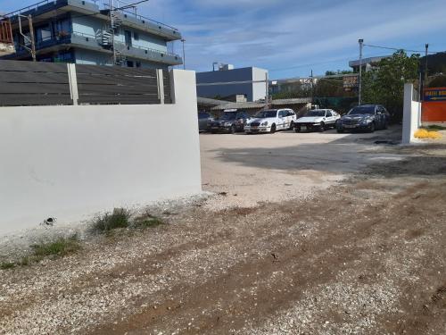 a parking lot with a white wall and cars parked at Hotel Astoria in Igoumenitsa