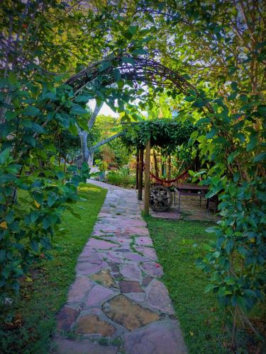 a garden path with an arch and a bench at Pousada Zazen in Vale do Capao