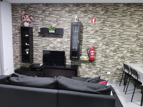 a living room with a couch and a brick wall at Casa de férias e fins de semana,1 in Esposende