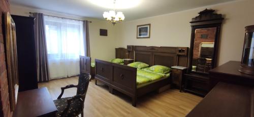 a bedroom with a bed and a dresser and a table at POKOJE GOŚCINNE MAJKA Apartament Stare jest Piękne in Mrągowo