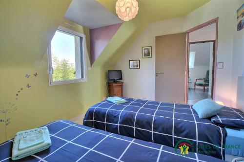 1 dormitorio con 2 camas y ventana en VILLA LE NID BRETON en Bignan