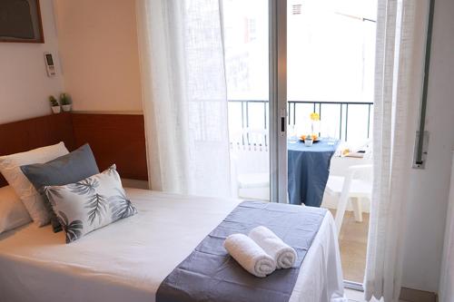 ein Schlafzimmer mit einem Bett mit zwei Handtüchern darauf in der Unterkunft Hostal Can Gil in Pineda de Mar