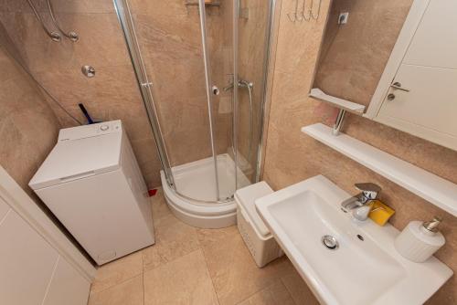 een badkamer met een douche, een wastafel en een toilet bij Apartment Peace in Kotor