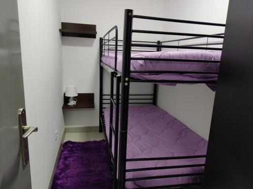 2 Etagenbetten in einem kleinen Zimmer mit violetter Bettwäsche in der Unterkunft Casa de férias e fins de semana,1 in Esposende