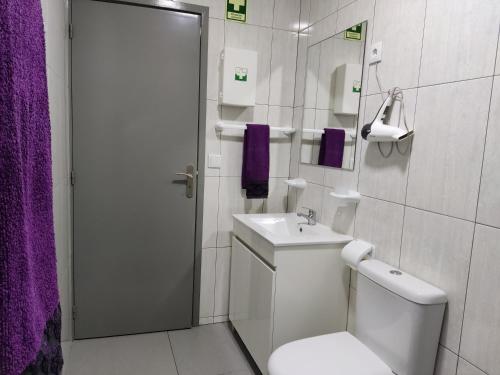 a white bathroom with a toilet and a sink at Casa de férias e fins de semana,1 in Esposende