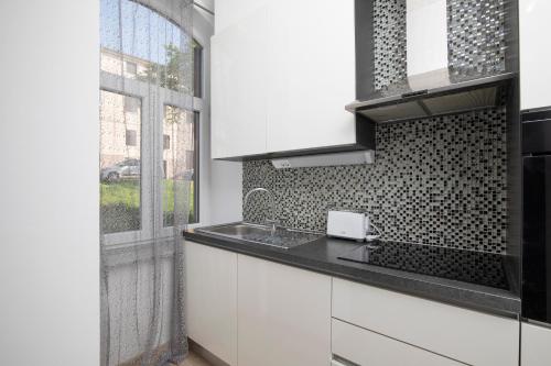 een keuken met witte kasten en een raam bij Palazzine apartments in Pula