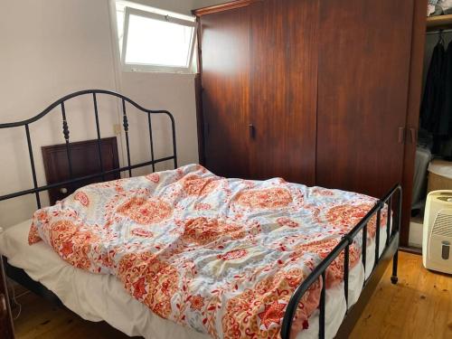 - un lit avec une couverture fleurie dans une chambre dans l'établissement Relaxing house by the beach - Casa Rosa, à Horta