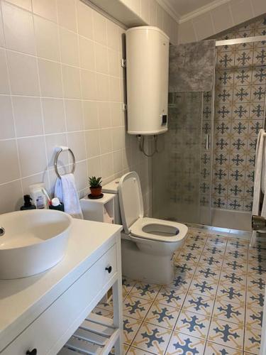 a bathroom with a toilet and a sink and a shower at Relaxing house by the beach - Casa Rosa in Horta