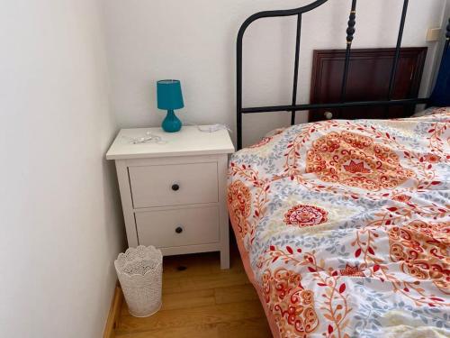 a bedroom with a bed and a night stand with a lamp at Relaxing house by the beach - Casa Rosa in Horta