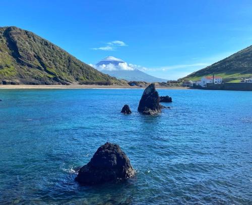 a large body of water with some rocks in it at Relaxing house by the beach - Casa Rosa in Horta