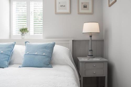 a bed with blue pillows and a lamp on a night stand at St Tudy Inn in Bodmin
