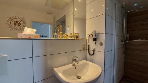 een witte badkamer met een wastafel en een spiegel bij Leipzig Ferienwohnung in ruhiger Lage in Leipzig