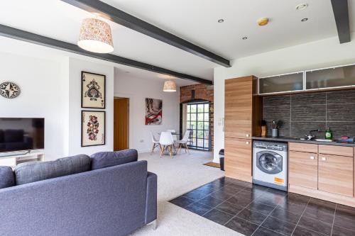 a living room with a couch and a dishwasher at Clock Towers, 2 Bed, Stockton Heath, Warrington, Parking in Warrington
