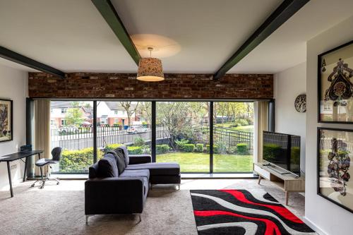 a living room with a couch and a tv at Clock Towers, 2 Bed, Stockton Heath, Warrington, Parking in Warrington