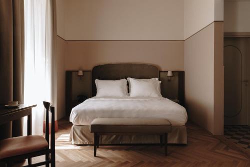 a bedroom with a large bed with white pillows at Parkhotel Mondschein, a Member of Design Hotels in Bolzano