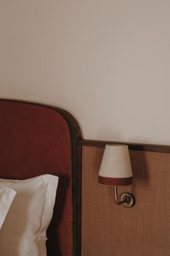 a lamp attached to the side of a bed at Parkhotel Mondschein, a Member of Design Hotels in Bolzano
