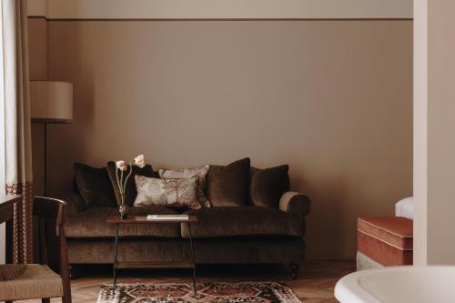 a living room with a couch and a table at Parkhotel Mondschein, a Member of Design Hotels in Bolzano