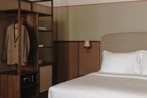 a bedroom with a white bed and a wooden book shelf at Parkhotel Mondschein, a Member of Design Hotels in Bolzano