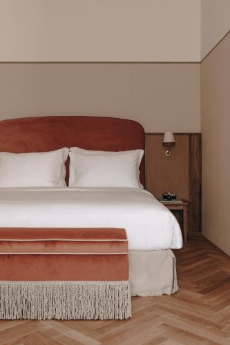 a bedroom with a large bed with a wooden headboard at Parkhotel Mondschein, a Member of Design Hotels in Bolzano