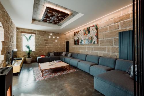 a living room with a blue couch and a brick wall at Palacio Condes de Cirac in Villalba de Rioja