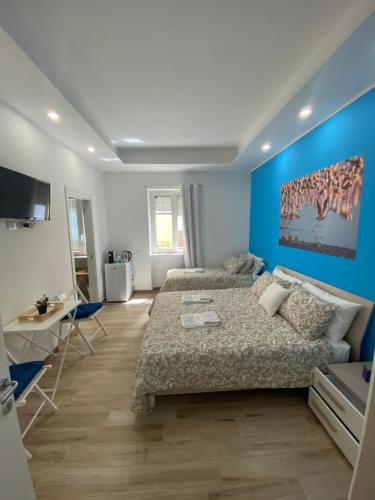 玛格丽塔萨沃亚Giglio di Mare rooms的一间带床和蓝色墙壁的卧室