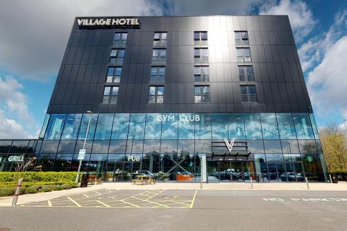 a building with a sign on the side of it at Village Hotel Portsmouth in Portsmouth