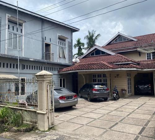 a couple of cars parked in front of a house at KoolKost Syariah near Jambi Prima Mall 2 (Minimum Stay 6 Nights) in Jambi