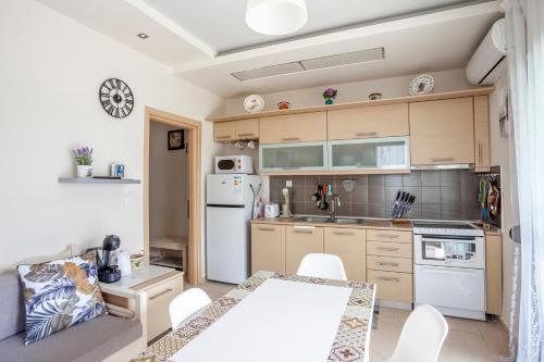 a kitchen with white appliances and a table and chairs at Sea side home Valentina in Hanioti