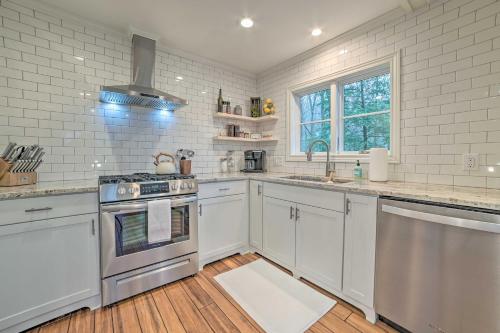 a kitchen with white appliances and white brick walls at Harbor Springs Retreat about 5 Mi to Downtown and Beach! in Harbor Springs