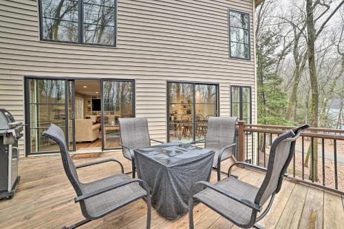 a patio with a table and chairs on a deck at Harbor Springs Retreat about 5 Mi to Downtown and Beach! in Harbor Springs