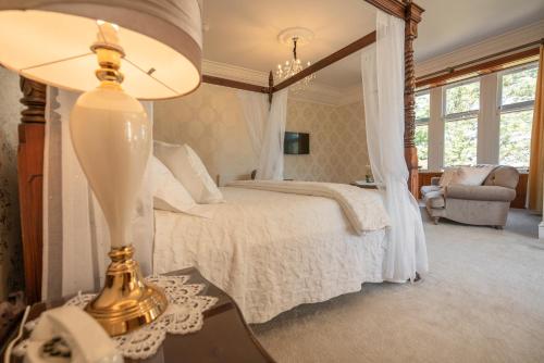 阿赫納欣的住宿－勒吉灣小屋酒店，一间卧室配有一张床和一张桌子上的台灯