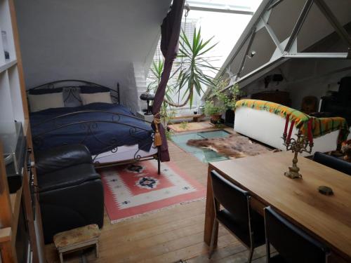 Artistic loft apartment with big sun terrace في خنت: غرفة بسرير وطاولة في غرفة