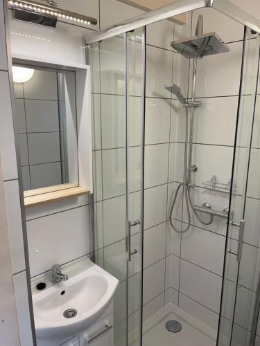 a bathroom with a glass shower and a sink at Domkoland in Dziwnówek