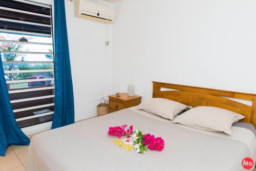Koungou的住宿－Villa Hawa，一间卧室,床上放着鲜花