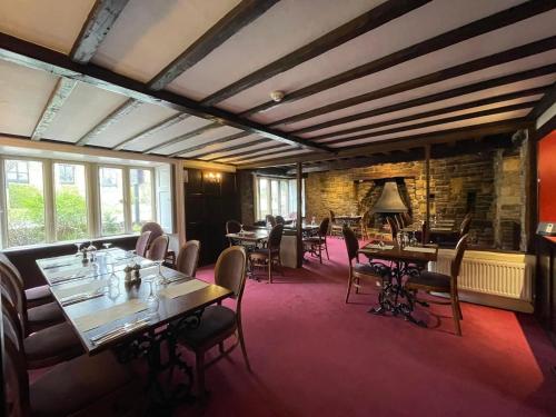 a restaurant with tables and chairs in a room at The Old Manor House Hotel in Keynsham