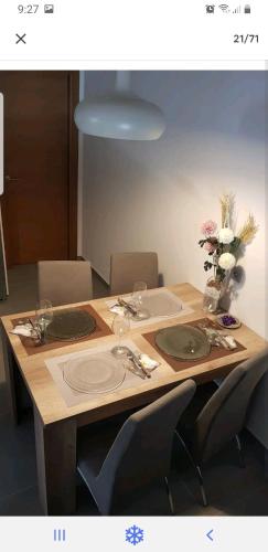 un tavolo in legno con sedie e un vaso di fiori di Las Terrazas II a Granadilla de Abona