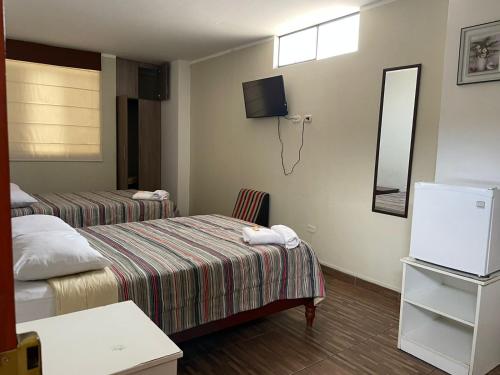Habitación de hotel con 2 camas y espejo en Hotel Plaza Barranca, en Barranca