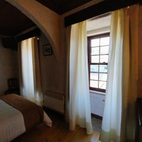 a bedroom with a bed and a window at Casa d`Avó Ná in Termas de Sao Pedro do Sul