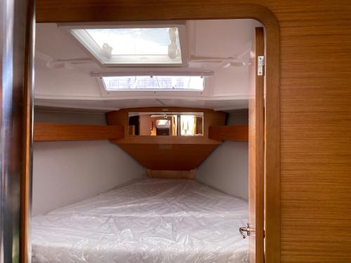 een kleine kamer met een bed en een dakraam bij TROIA - Veleiro em marina in Troia