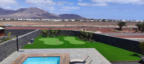 een uitzicht over een golfbaan in een resort bij Villa Geneva - Relax y diversión in Playa Blanca