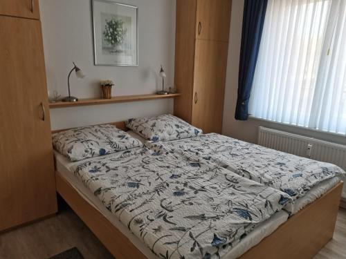 ein Schlafzimmer mit einem Bett mit einer Bettdecke darauf in der Unterkunft Haus Dortmund in Borkum