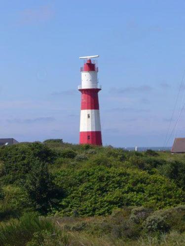 einen roten und weißen Leuchtturm auf einem Hügel in der Unterkunft Haus Dortmund in Borkum