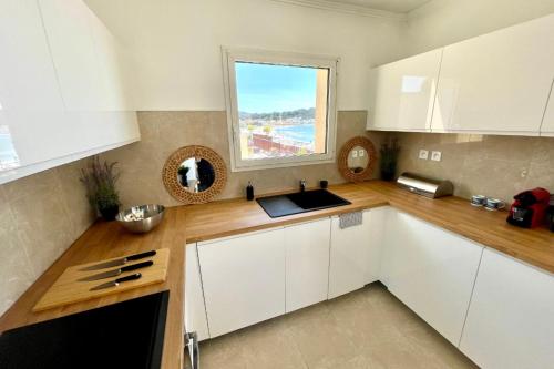 eine Küche mit weißen Schränken und einem Fenster in der Unterkunft Magnificent 82m With Terrace And In Front Of Sea in La Seyne-sur-Mer