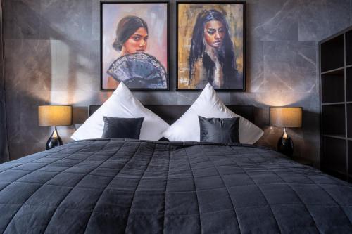 um quarto com uma cama grande e duas fotografias na parede em GelsenDesign II - Gemütliches Premium Apartment em Gelsenkirchen