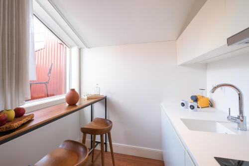 a kitchen with a counter and a sink and a window at Porto River Infante in Porto