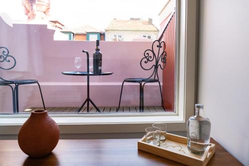 a table with two glasses and a bottle of wine on a balcony at Porto River Infante in Porto
