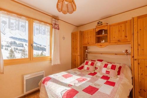 um quarto com uma cama com uma colcha em Apartment with Balcony and View em Le Grand-Bornand