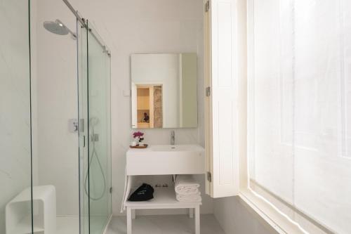 a white bathroom with a sink and a shower at Porto River Infante in Porto