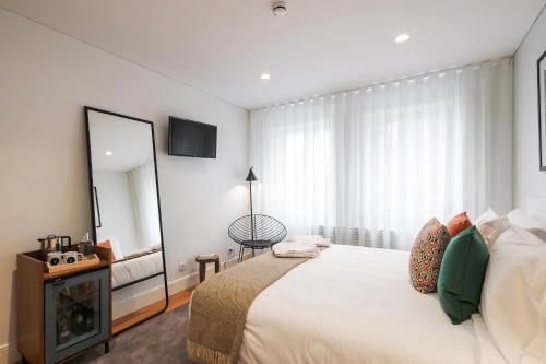 a bedroom with a large bed and a mirror at Porto River Infante in Porto